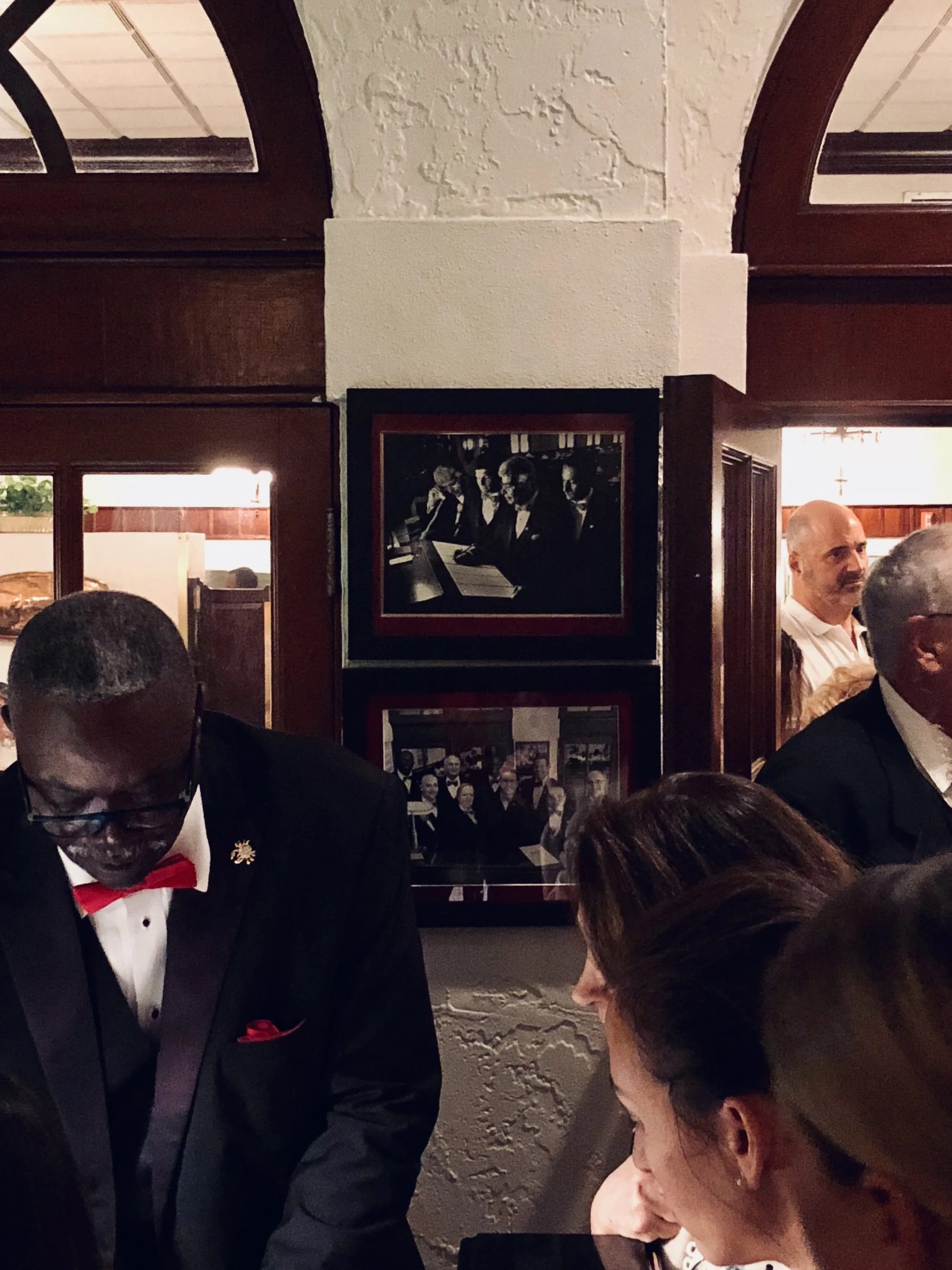 The framed photographs hanging at the entrance of Joe's Stone Crab